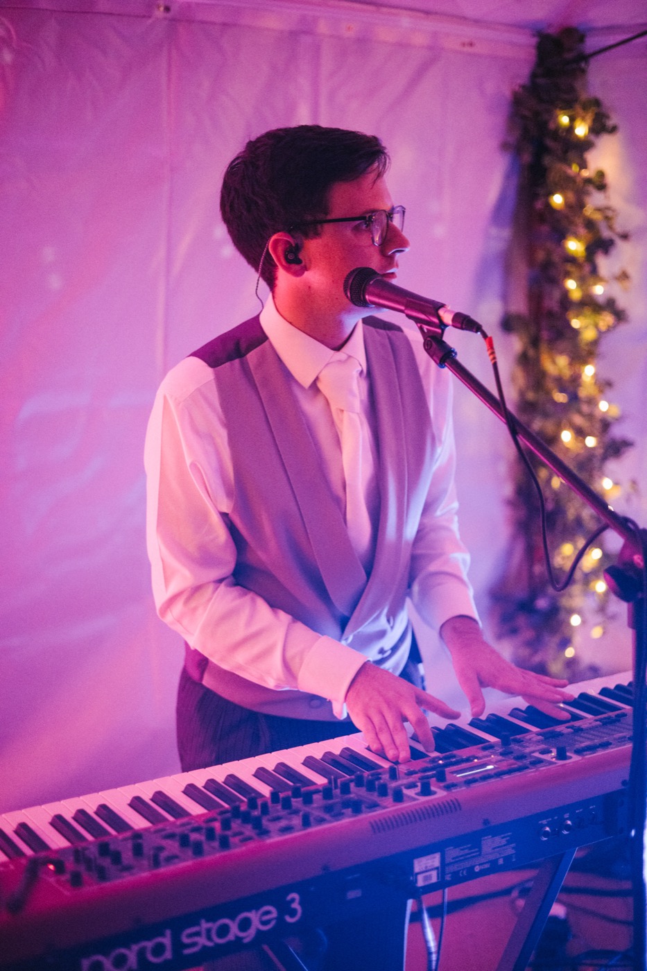 James singing and playing keys at a Nord keyboard